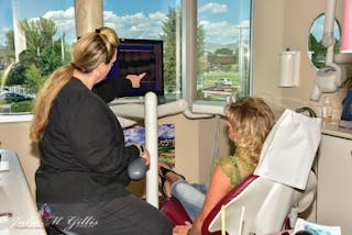 Figure 2: The treatment assistant is explaining a dental concern. Dr. Gillis&apos; office has wide-screen monitors, intraoral cameras, and x-ray equipment in each treatment room.