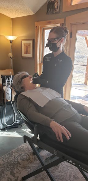 Abigail Hughey, BSDH, RDH, owner and founder of Open Mobile Care, provides treatment for a senior in the comfort of her home in Lyons, Colorado.