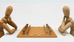 Two wooden mannequins playing chess Two wooden mannequins playing chess
