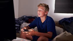 Teen boy staring at screen playing a video game Teen boy staring at screen playing a video game