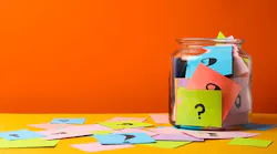 a jar filled with colorful notes that have question marks on them
