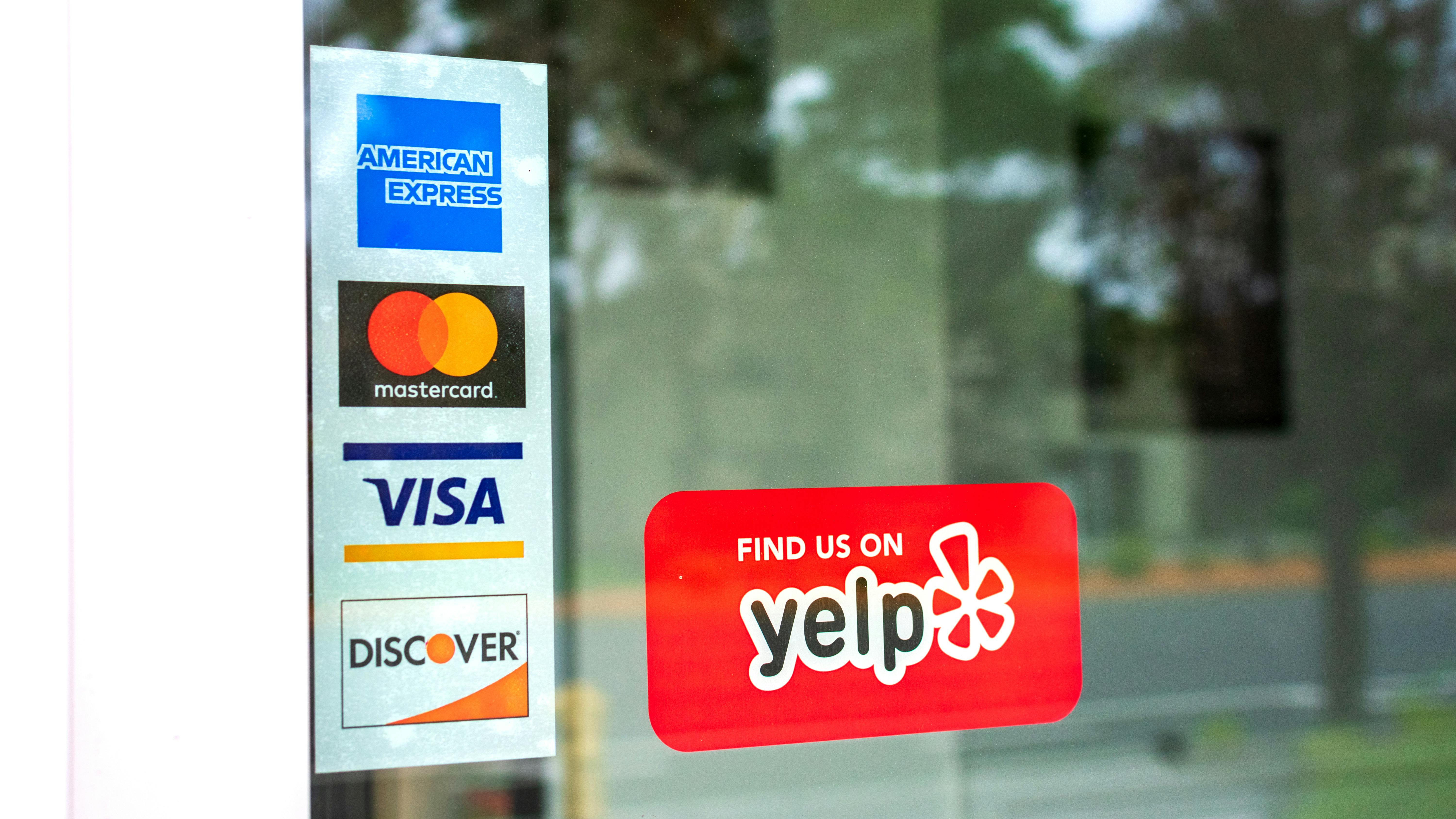 front of business door with credit card info and Yelp sign