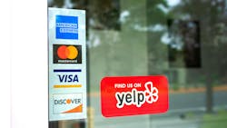 front of business door with credit card info and Yelp sign front of business door with credit card info and Yelp sign