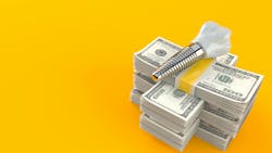 Stack of money with dental implant on top Stack of money with dental implant on top