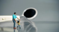 Miniature toy father and child in the foreground with dental instruments behind Miniature toy father and child in the foreground with dental instruments behind