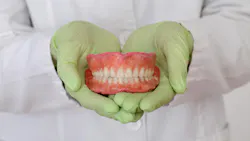 gloved hands holding a model of teeth gloved hands holding a model of teeth