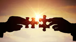 two hands holding puzzle pieces together