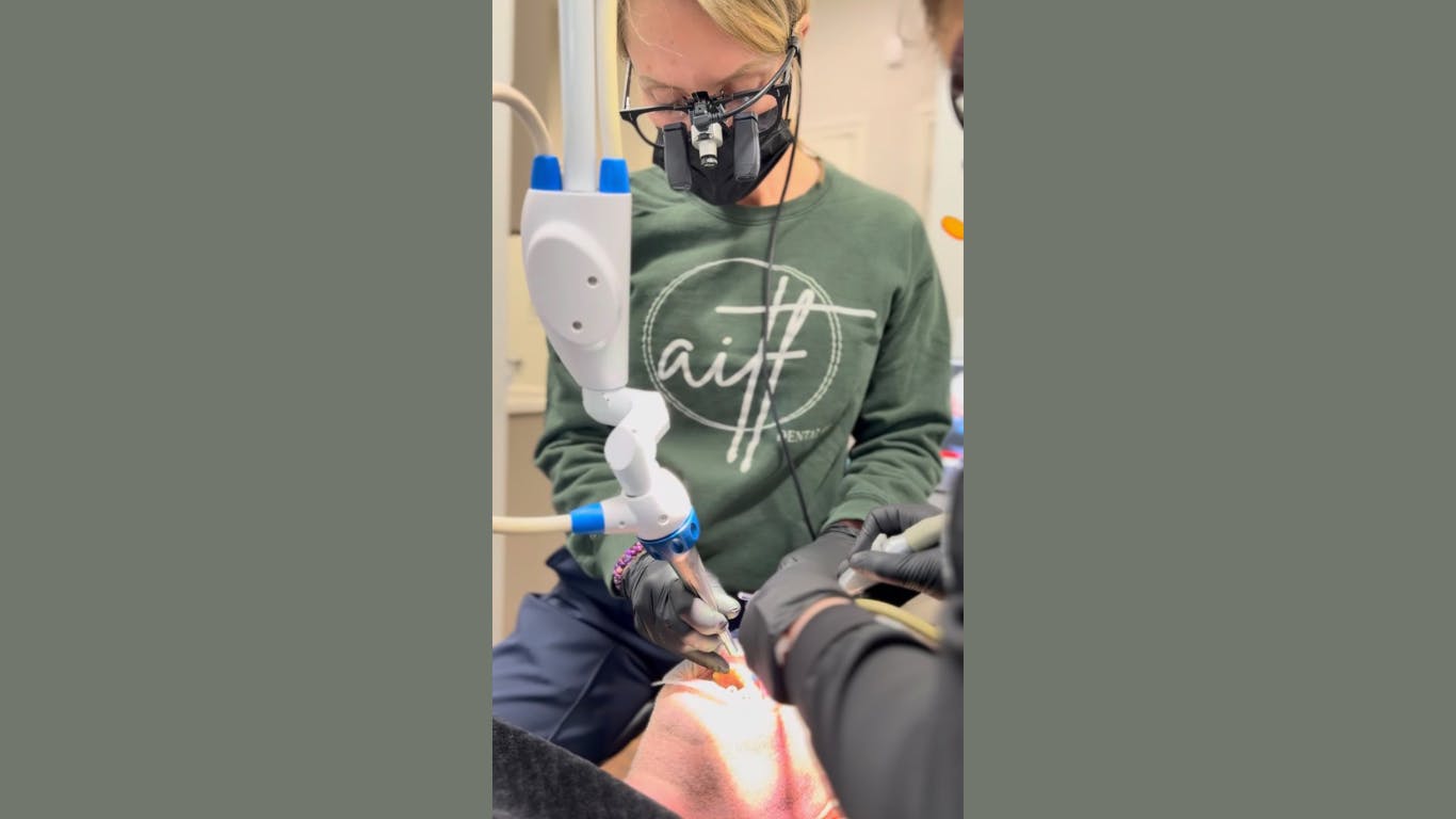 a dentist using a laser on a patient